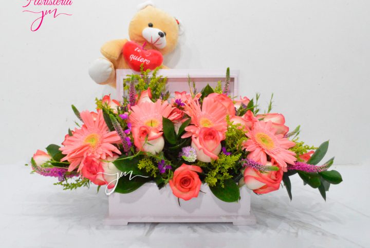 Caja de madera blanca con flores rosadas y un osito de peluche.