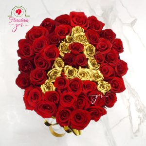 Caja redonda decorativa con rosas rojas y doradas, con un mensaje de "Feliz Cumpleaños" en letras doradas.