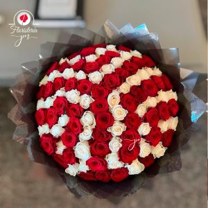 Arreglo floral circular con diseño de rosas rojas y blancas en patrón de espiral.