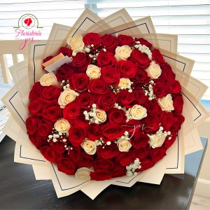 Ramo de rosas rojas y frescas con detalles de paniculata, envuelto en papel elegante
