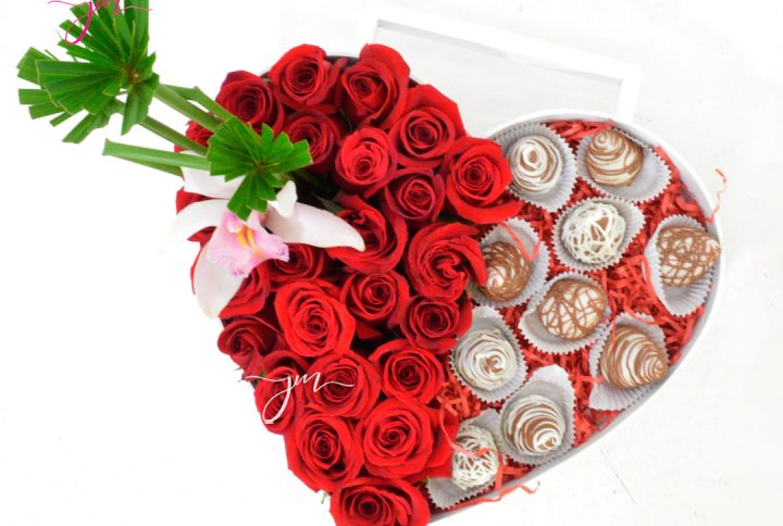 Arreglo floral en forma de corazón con rosas rojas y fresas cubiertas de chocolate, ideal para regalar en San Valentín.