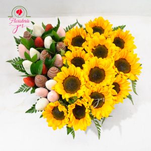 Arreglo floral en forma de corazón con girasoles vibrantes y fresas cubiertas de chocolate, un detalle lleno de alegría y sabor.