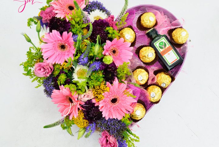 Caja en forma de corazón con flores en tonos pastel y bombones Ferrero Rocher, un regalo elegante y dulce.
