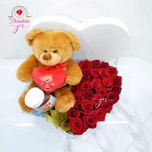 Caja en forma de corazón con rosas rojas, un oso de peluche y frasco de Nutella, ideal para sorprender en San Valentín.
