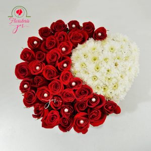 Arreglo floral en base negra con diseño de medio corazón en rosas rojas y crisantemos blancos