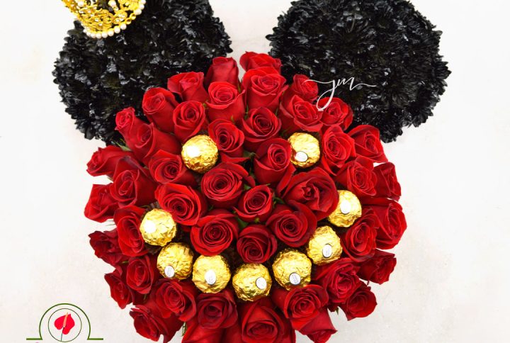 Arreglo floral en forma de Mickey Mouse con rosas rojas, chocolates Ferrero Rocher y una corona dorada.