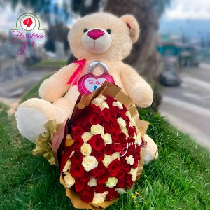 Arreglo floral con un oso de peluche gigante y un ramo de rosas rojas y blancas