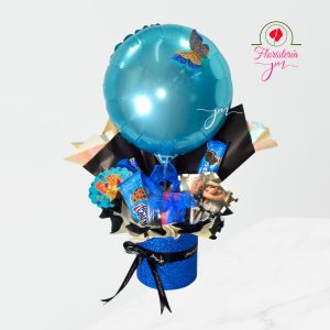 Caja de regalo azul con globos y selección de snacks.